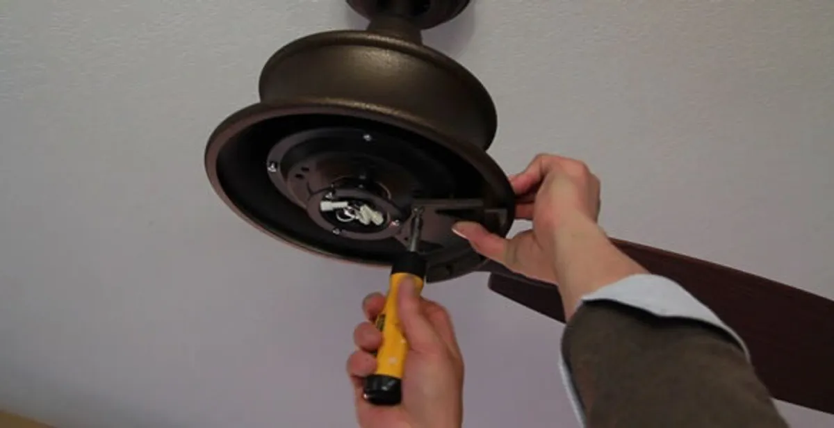 Electrician installing ceiling fan mounting bracket and fixture in Lakeland, FL